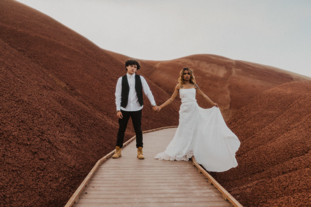 Couple looking at the camera during their elopement at Painted Hills in Oregon.